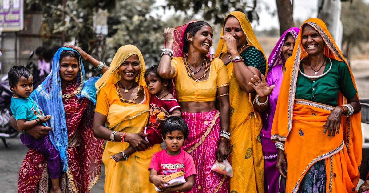 A lively group of women and children in traditional Rajasthani attire, showcasing vibrant culture and joyful expressions.